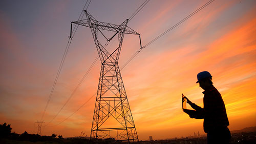 silhouette of man and power lines against clouds